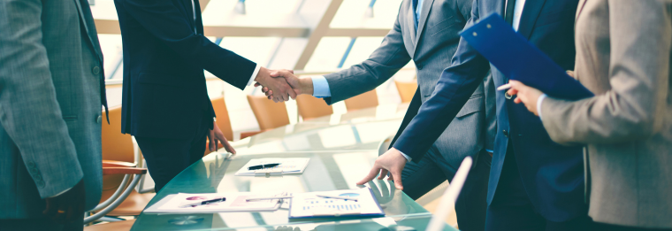 a group of people shaking hands at a conference table.